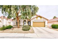 Charming single-story home with a well-manicured front yard and a two-car garage at 672 Hitchen Post Dr, Henderson, NV 89011