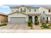 Charming two-story home with a tile roof, gray exterior, and well-maintained landscaping at 7502 Lush Oasis Ave, Las Vegas, NV 89113