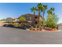 Exterior view of building with lush landscaping, covered parking, and palm trees on a sunny day at 8805 Jeffreys St # 1003, Las Vegas, NV 89123