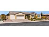 Inviting single-story home with a neutral color palette, three-car garage, and well-manicured front yard at 9240 Northfield Park Ct, Las Vegas, NV 89148