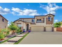 Charming two-story home with a three car garage, stone steps and green landscaping at 15 Imposing Knoll Ave, Henderson, NV 89002