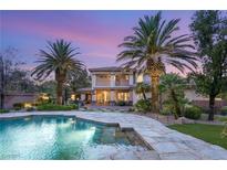 Stunning backyard with a spacious pool and spa, lush landscaping, and a covered patio for outdoor entertaining at 2285 Villefort Ct, Las Vegas, NV 89117