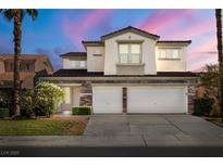 Charming two-story home featuring a three-car garage, stone accents, and beautifully landscaped front yard at 323 Harpers Ferry Ave, Las Vegas, NV 89148