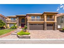 Two-story home featuring a dual garage, a brick driveway, and balcony at 3738 Amber Lantern Cir, Las Vegas, NV 89147