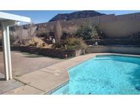 Backyard pool featuring cool blue waters with decorative retaining wall and mountain views at 424 Wright Way, Henderson, NV 89015