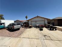 Single story home with a two-car garage and a cluttered driveway with a truck at 6271 Explorer Dr, Las Vegas, NV 89103