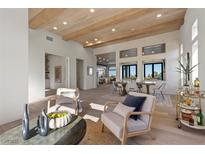 Open-concept living room with wood-beamed ceilings, white brick accent wall, and seamless flow to dining and kitchen areas at 2508 Faiss Dr, Las Vegas, NV 89134