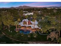 Stunning aerial view of a luxury home with a backyard pool, lush landscaping, and mountain views at 2961 Augusta Dr, Las Vegas, NV 89109