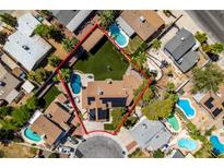 Expansive aerial view of a desert home with lush backyard, sparkling pool, mature trees, and solar panels at 3708 Lorraine Ln, Las Vegas, NV 89120