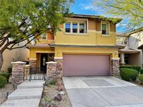 Charming two-story home with a two-car garage, stone accents, and manicured landscaping offers great curb appeal at 5361 Candlespice Way, Las Vegas, NV 89135