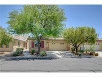Charming single-story home featuring a desert landscape, two-car garage and ample trees in front at 5916 Sorto Lago St, North Las Vegas, NV 89081