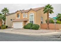 Two-story home featuring a tile roof, two-car garage, desert landscaping, and mature palm trees at 6007 Turtle River Ave, Las Vegas, NV 89156
