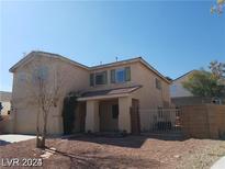 Two-story home featuring desert landscaping, a two-car garage, and a covered porch at 7517 Apple Cider St, Las Vegas, NV 89131