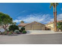 Charming single-story home with a two-car garage, beautiful landscaping, and blue sky in a quiet neighborhood at 819 Sandsprings St, Henderson, NV 89011