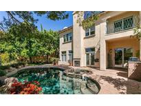 Beautiful backyard pool and spa with stone patio and stucco house at 9001 Opus Dr, Las Vegas, NV 89117