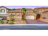 Inviting home features desert landscaping, an attached two-car garage, and a private front yard at 11334 Patores St, Las Vegas, NV 89141