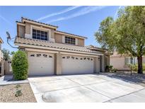 Tan two-story home with three-car garage, desert landscaping, and a tile roof at 12 Golden View St, Henderson, NV 89012