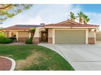 Inviting single-story home featuring a well-manicured lawn, desert landscaping, and an attached two-car garage at 1393 Calmview Pl, Las Vegas, NV 89110