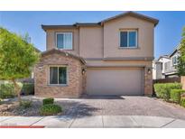 Charming two-story home featuring brick accents, a paved driveway, and a well-maintained front yard with lush greenery at 3195 Hazy Hills Ave, Henderson, NV 89052