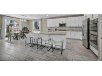 Modern kitchen boasts stainless steel appliances, granite countertops, and an island with bar seating at 3195 Hazy Hills Ave, Henderson, NV 89052