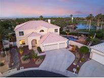 Stunning aerial view of a two-story home featuring a pool, lush landscaping, and a three-car garage at 352 Angels Trace Ct, Las Vegas, NV 89148