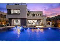 Stunning modern home with a luxurious pool featuring a fire feature and integrated lounge chairs at 5 Highland Cove Ln, Henderson, NV 89011