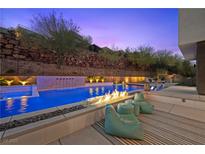 Inviting backyard pool featuring a fire pit, waterfall feature, and comfortable lounge seating at 5 Highland Cove Ln, Henderson, NV 89011