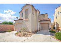 Two-story home featuring dual garages, desert landscaping, and stucco exterior at 6098 Darkfeather Way, Las Vegas, NV 89139