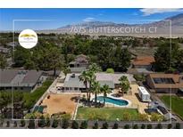 Stunning aerial view of a home with a pool, horse area, and RV parking in a lush, landscaped neighborhood at 7675 Butterscotch Ct, Las Vegas, NV 89131