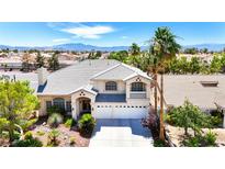 Charming two-story home featuring a well-manicured lawn, palm trees, a balcony, and a three-car garage at 9155 Harvest Homes St, Las Vegas, NV 89123