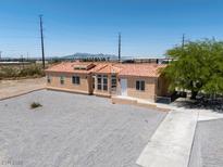 Charming single-story home featuring desert landscaping, a clay tile roof, and a welcoming front entrance at 2530 Commercial Dr, Pahrump, NV 89048