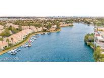 Expansive aerial view of waterfront homes with private docks and the city skyline in the background at 2608 Sun Reef Rd, Las Vegas, NV 89128