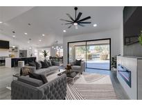 Open-concept living room featuring modern furnishings, a fireplace, and sliding glass doors to the outdoor space at 2905 Legend Dr, Las Vegas, NV 89134