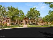 Stunning single-story home featuring lush trees, decorative stone facade, and a tiled roof at 38 Pebble Dunes Ct, Las Vegas, NV 89141