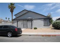 View of a gray, two-story home with a trellis over the front door and desert landscaping at 4015 Edgeford Pl, Las Vegas, NV 89102