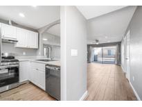 Bright kitchen featuring white cabinets, stainless steel appliances, and an open layout to the living area at 5000 Red Rock St # 120, Las Vegas, NV 89118