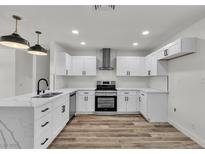 Bright kitchen features white cabinets, stainless steel appliances, and marble countertops at 5617 Reiter Ave, Las Vegas, NV 89108