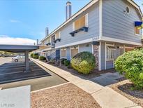Inviting two-story condo featuring a carport, charming landscaping, and beautiful exterior paint at 5861 Medallion Dr # 202, Las Vegas, NV 89122