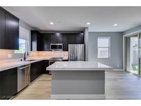 Modern kitchen features stainless steel appliances, island with quartz countertops, and sleek dark cabinets at 649 Tranquil Jade St, Las Vegas, NV 89138