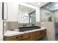 Modern bathroom features a vessel sink, marble countertops, and a glass-enclosed shower at 902 Possum Hill St, Henderson, NV 89014