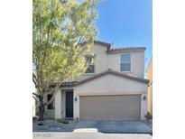 Beige two-story home with an attached two-car garage and a well-maintained front yard at 908 Shining Rose Pl, Henderson, NV 89052