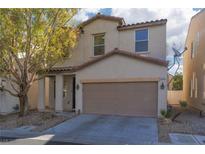 Charming two-story home featuring a two-car garage, neutral stucco, and manicured landscaping at 908 Shining Rose Pl, Henderson, NV 89052
