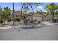 Inviting single-story home with a two-car garage, desert landscaping, and a tiled roof at 10017 Bundella Dr, Las Vegas, NV 89134
