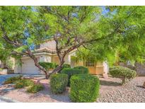 Inviting two-story home featuring mature landscaping, a tiled roof and charming curb appeal at 10716 Aire Dr, Las Vegas, NV 89144