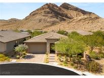 Beautiful single-story home with desert landscaping and brick driveway in front of a mountain at 10890 Red Yucca Dr, Las Vegas, NV 89138