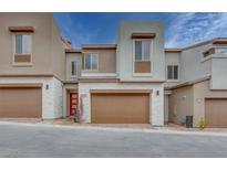 Stylish townhome showcasing a two-car garage, modern architecture, and a red front door at 11904 Glide Reflection Ave, Las Vegas, NV 89138
