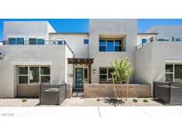 Contemporary home exterior with a covered entrance, block wall and desert landscaping at 1485 Melodic Lark Ln, Las Vegas, NV 89138