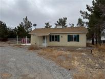 Cozy single-story home with a gravel yard, mature trees, and a functional satellite dish at 2451 E Falcon St, Pahrump, NV 89048