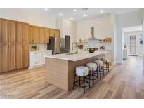 Bright kitchen with wood floors, a large island with seating, and stainless steel appliances at 4314 Livorno Ave, Las Vegas, NV 89141