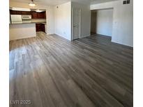 Bright living room featuring modern, wood-look flooring and a view into the kitchen area at 5251 Indian River Dr # 271, Las Vegas, NV 89103